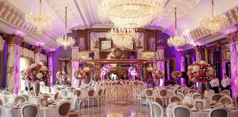Luxurious dinner hall with large crystal chandeliers hanging fro
